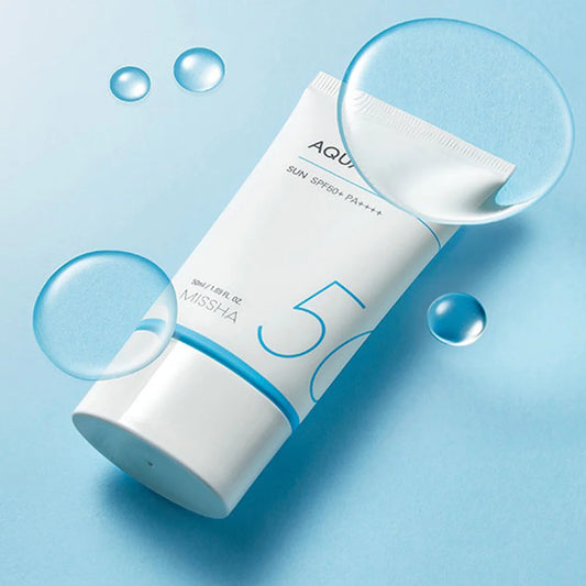 A tube of MISSHA Safe Block Aqua Sun Oily Skin SPF50+ PA++++ sunscreen with a blue cap, displayed on a blue background with rising bubbles around it, indicating its hydrating properties.